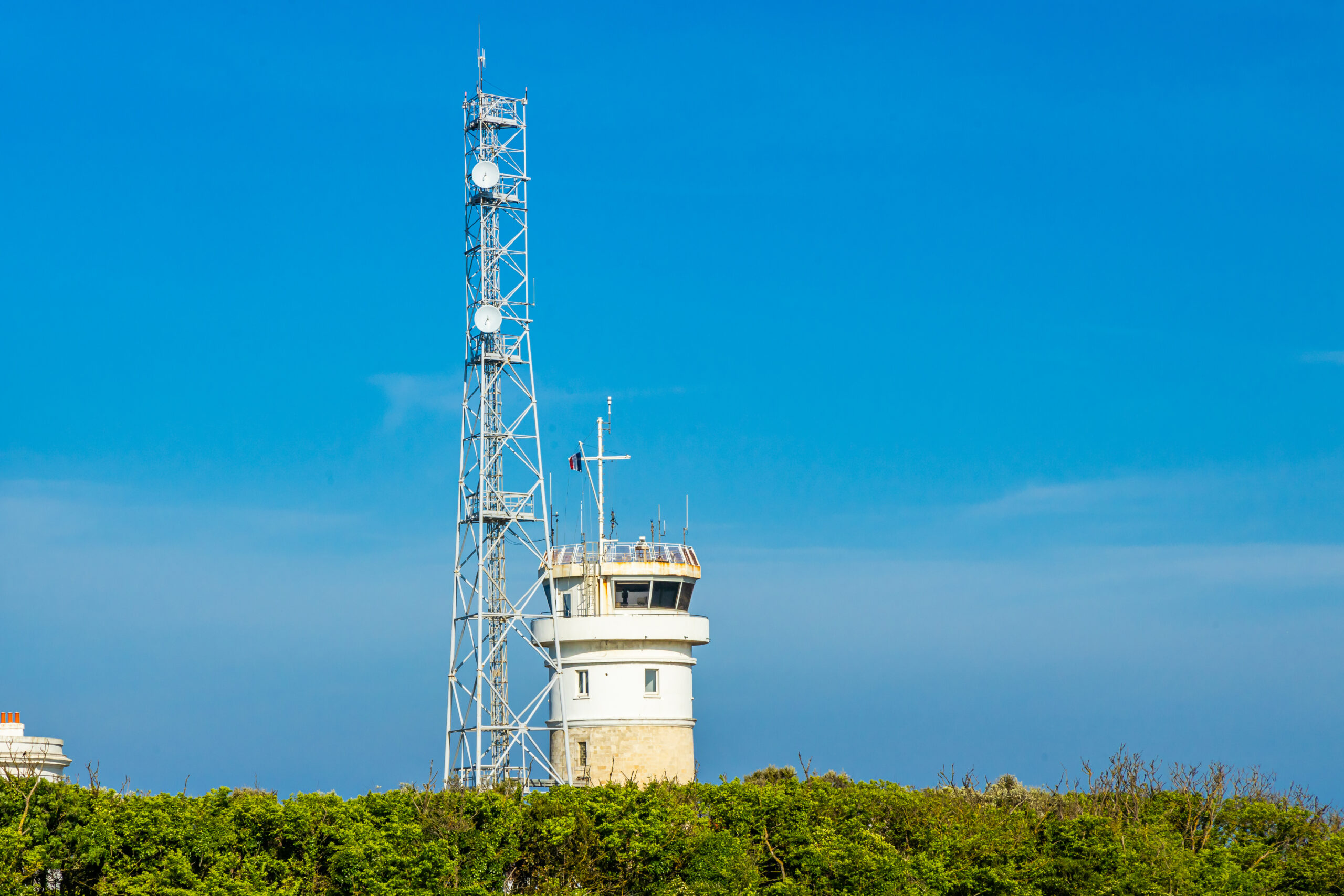 lighthouse and cell tower with blue sky
