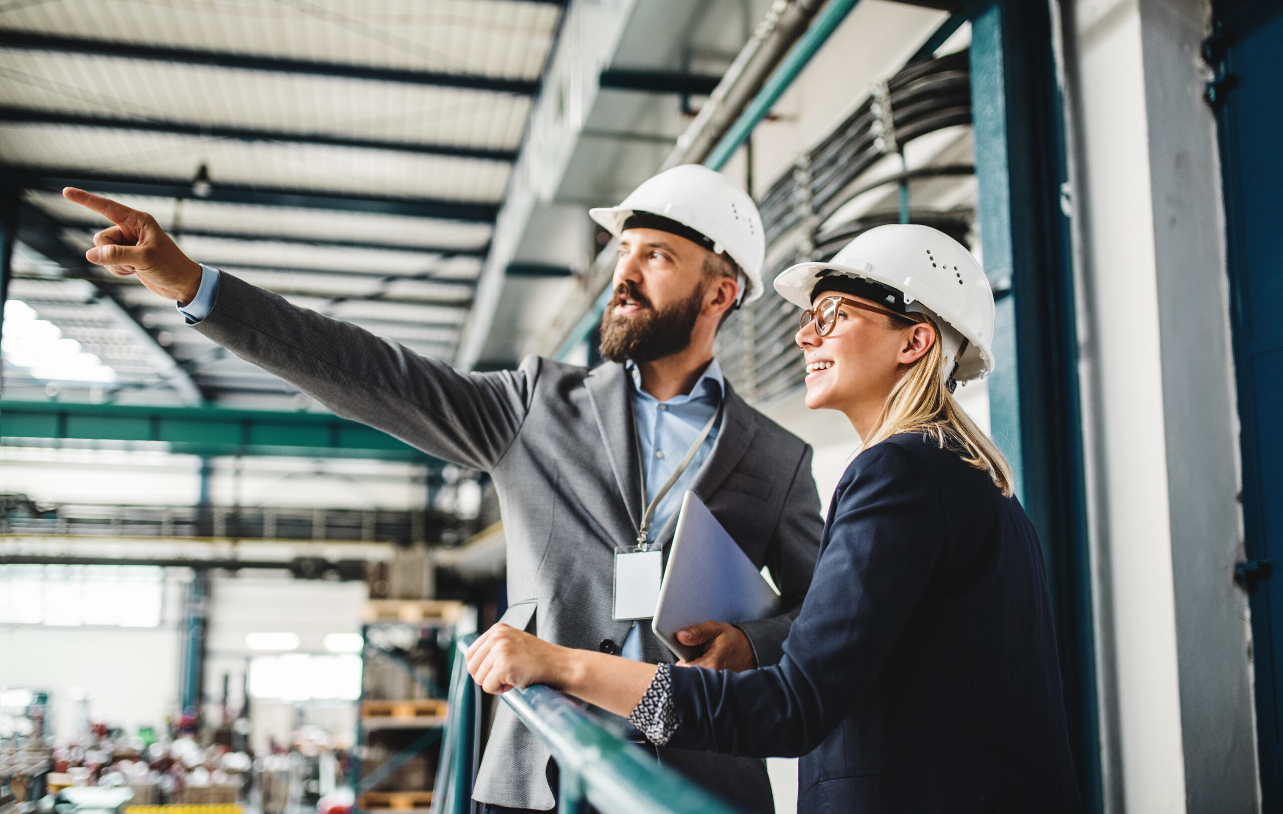 Two people in hard hats pointing