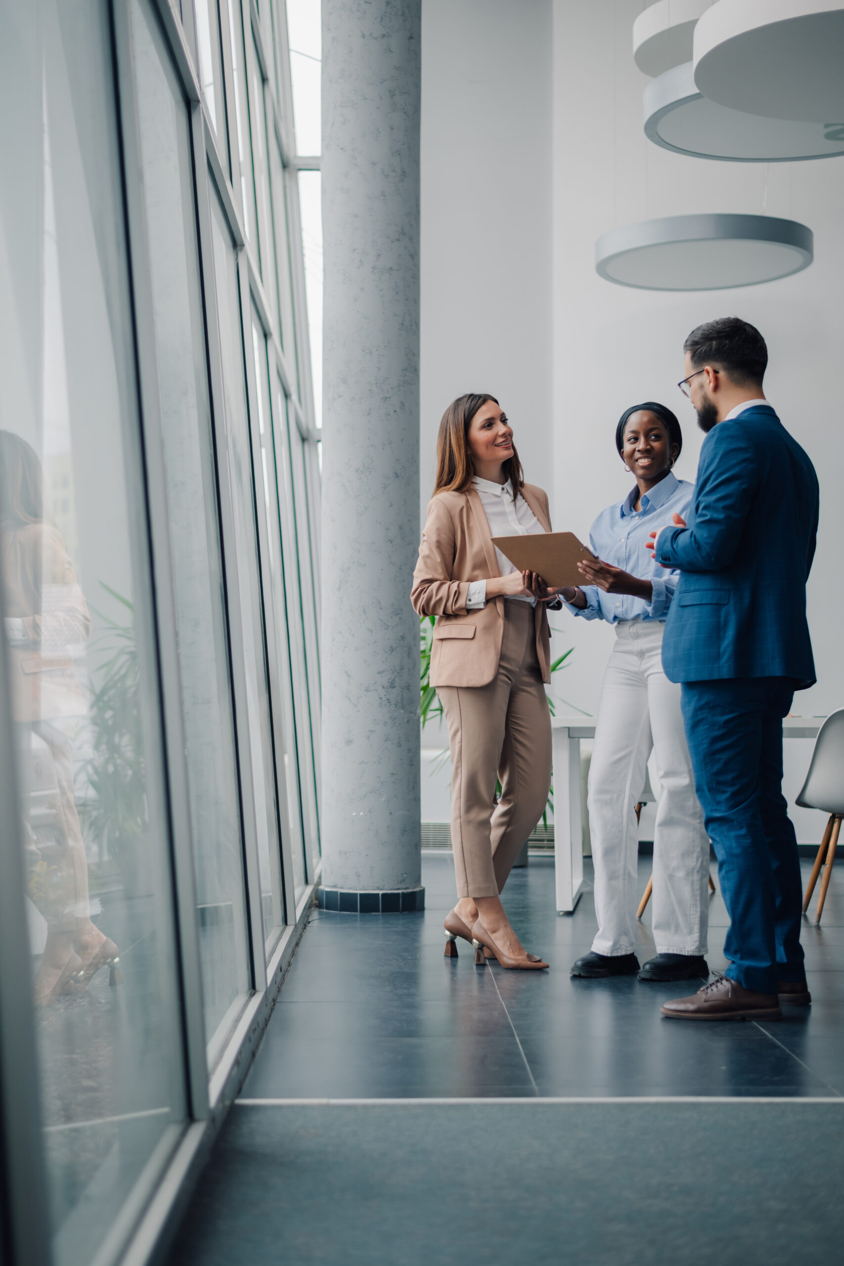 Three people in business attire standing and talking