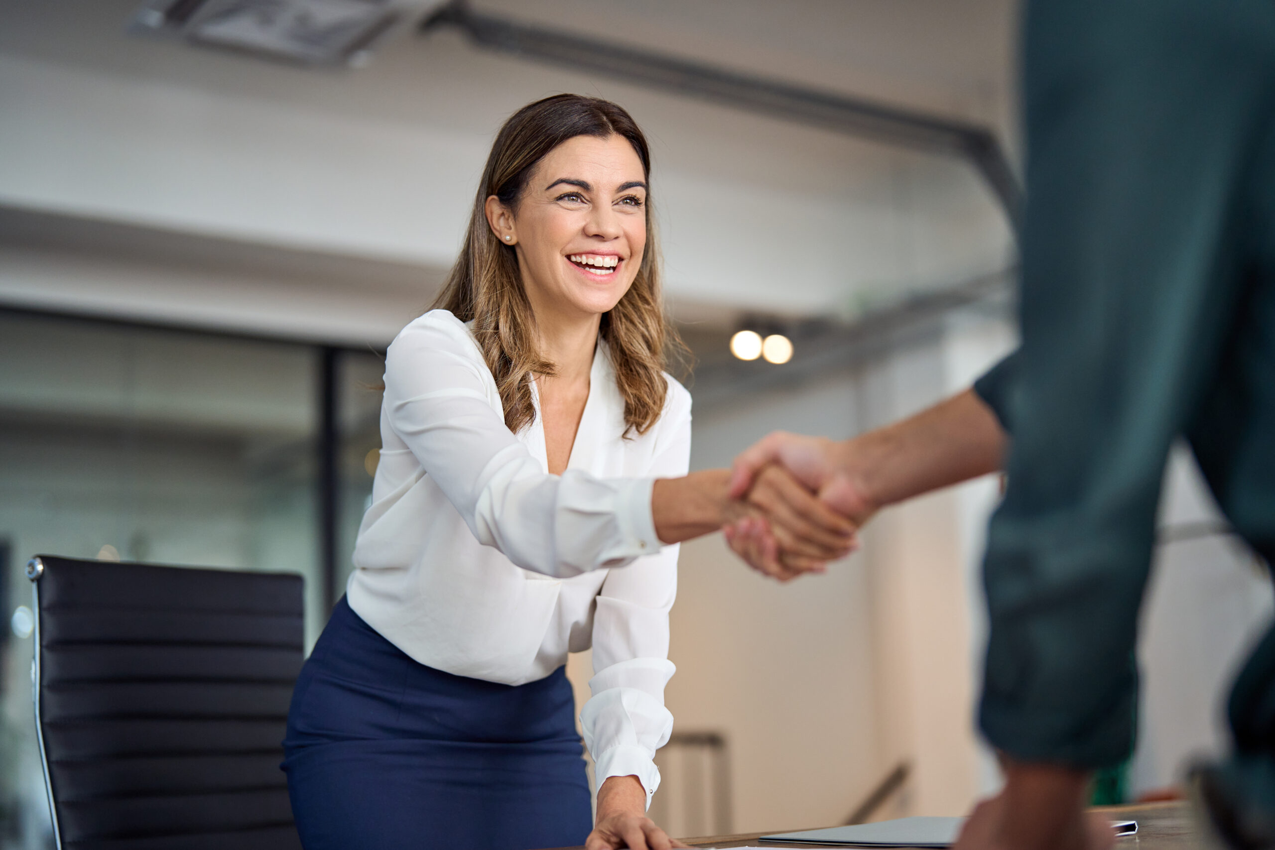 Woman shaking a hand and smiling