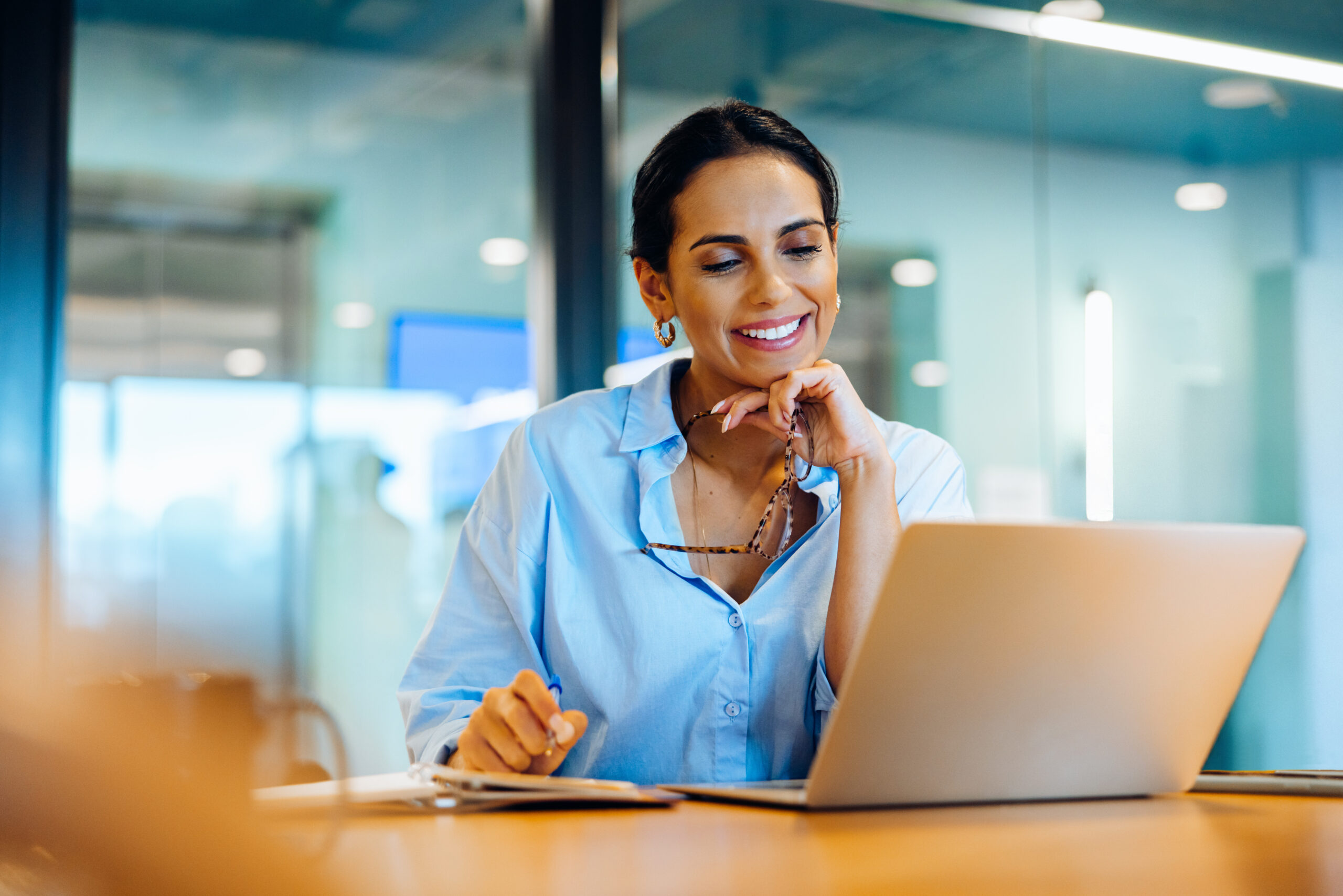 Woman smiling in an office in front of computer