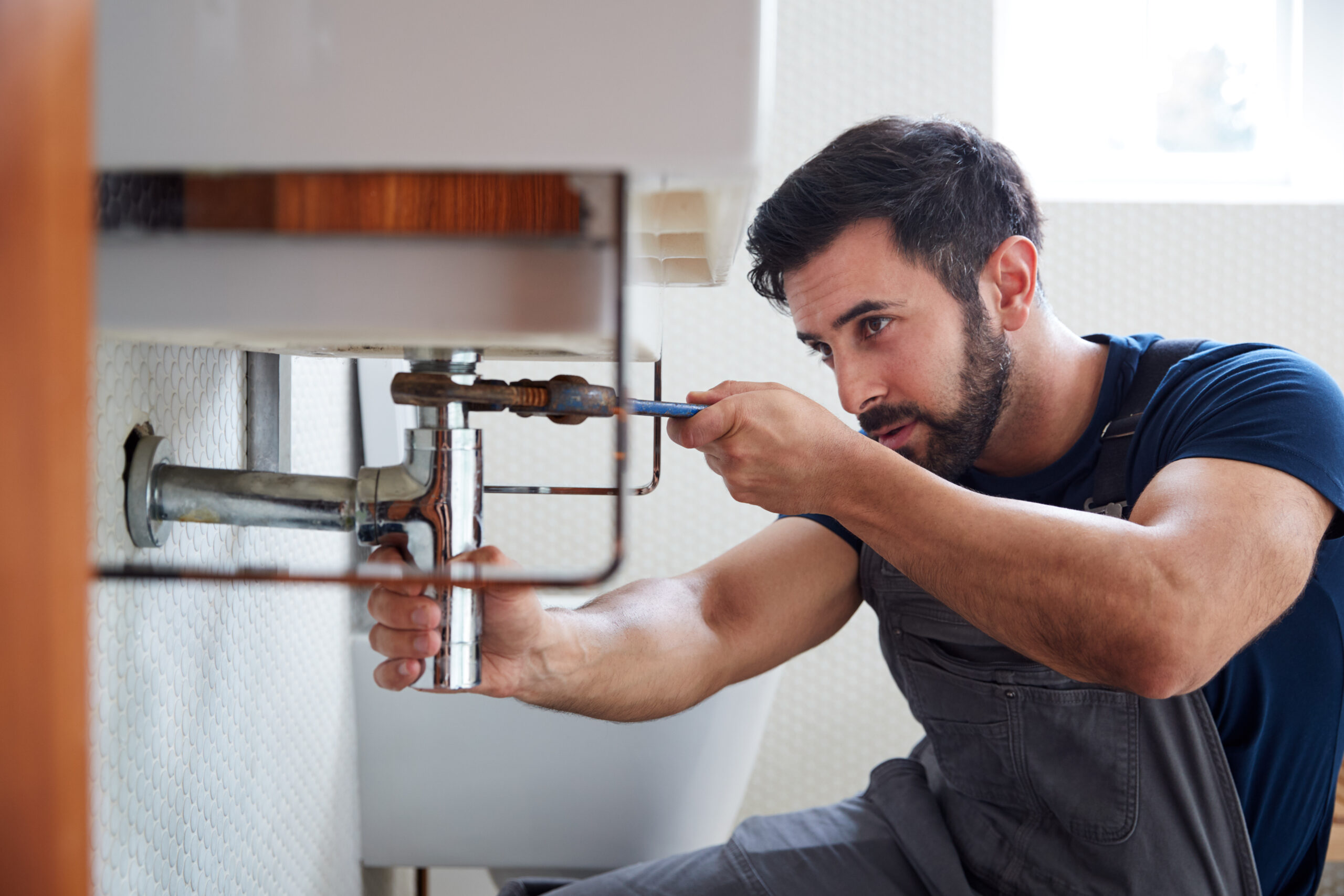 Plumber working on pipes